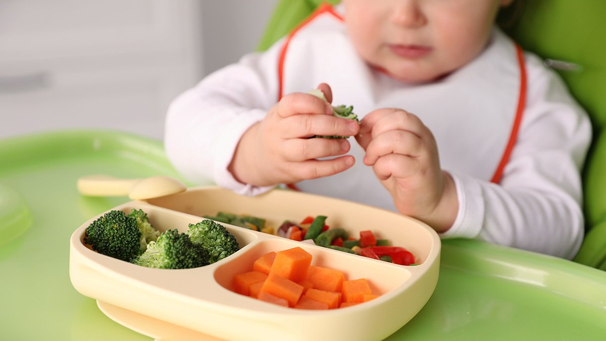 Litet barn äter grönsaker