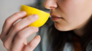Kvinna luktar på en citron