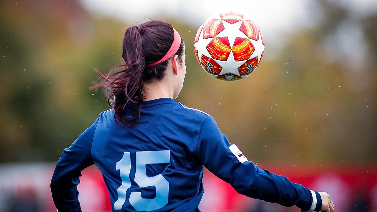 Kvinnlig fotbollspelare med boll nära huvudet