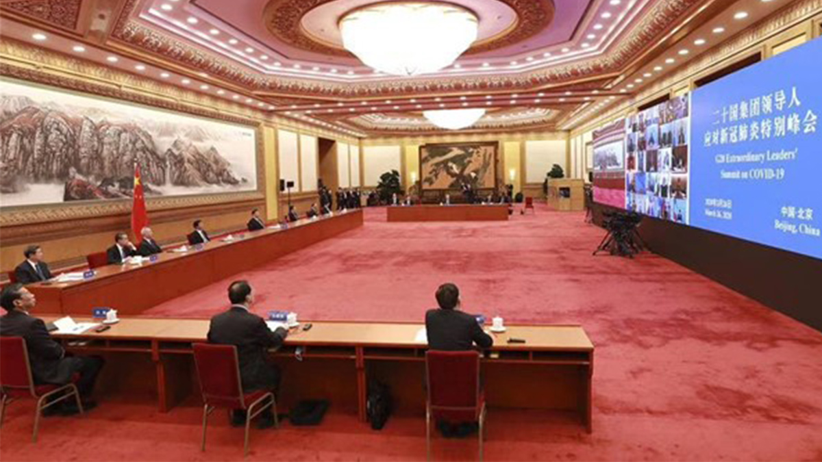 Xi Jinping och andra kinesiska beslutsfattare bakom ett långt skrivbord i en sal med röd heltäckningsmatta.