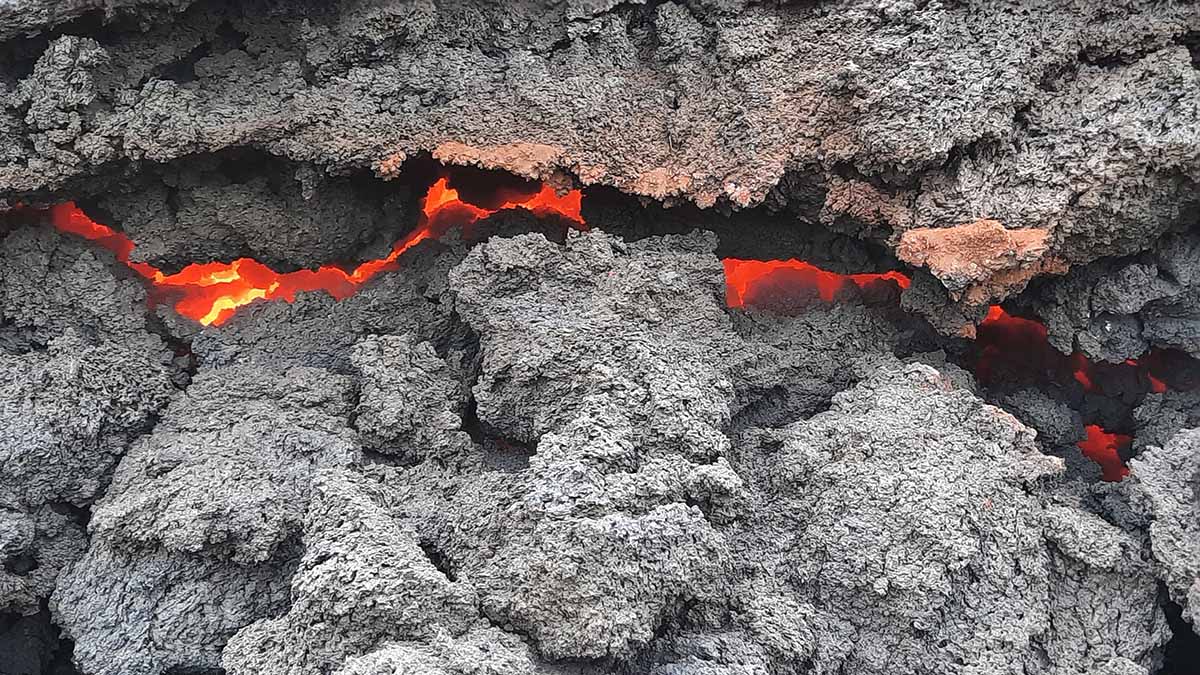 Glödande lavaström under sten