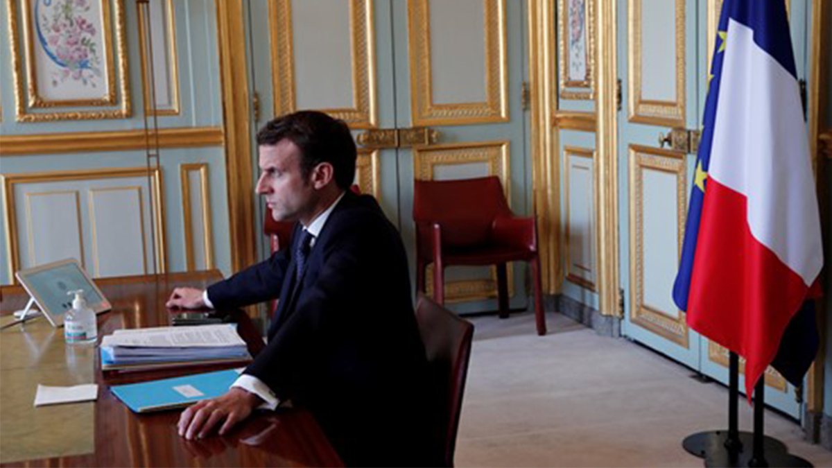 Emmanuel Macron bakom ett skrivbord.