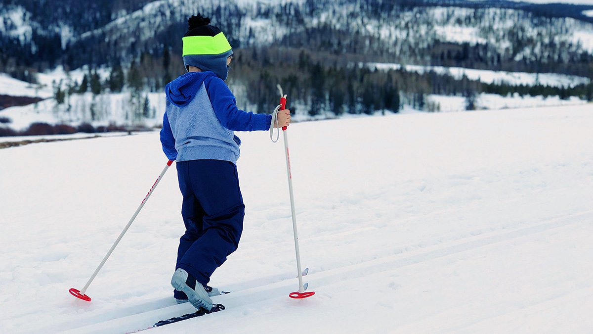 Ett barn åker skidor på fjället