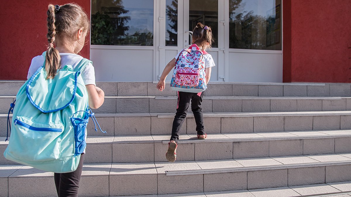 Två flickor på väg mot skolans entré