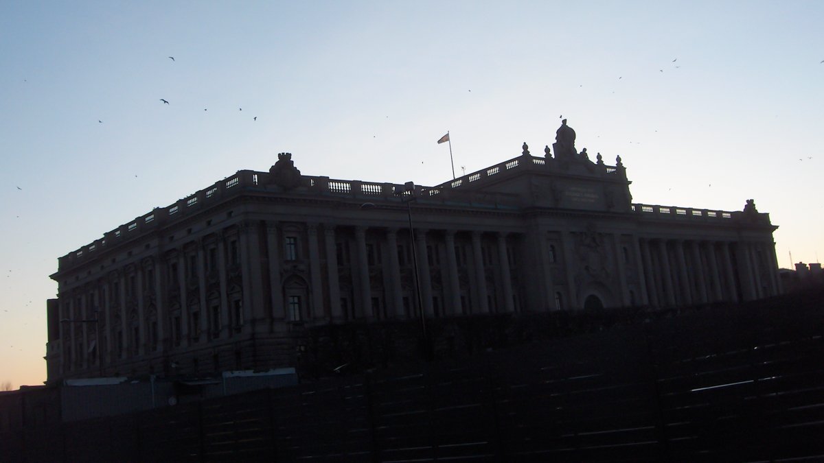 bild av riksdagshuset i så starkt motljusatt man nästan bara ser siluetten