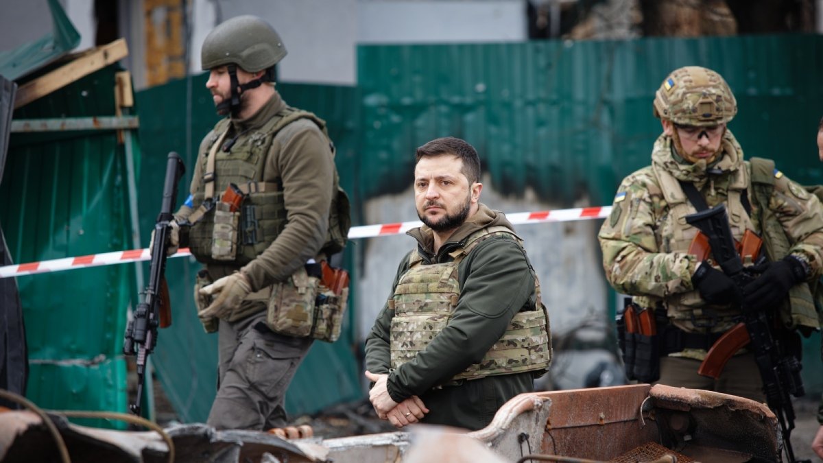 Tre män i skottsäkra väster, klädda för krig, med vapen. Ukraina 2022.