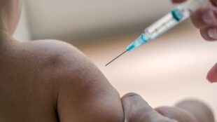 Barn får vaccinspruta
