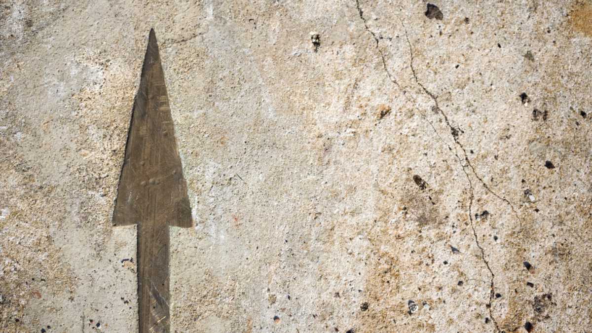 arrow etched on old stone wall