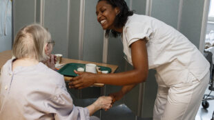 Sjuksköterska tillsammans med äldre kvinna på ett äldreboende.