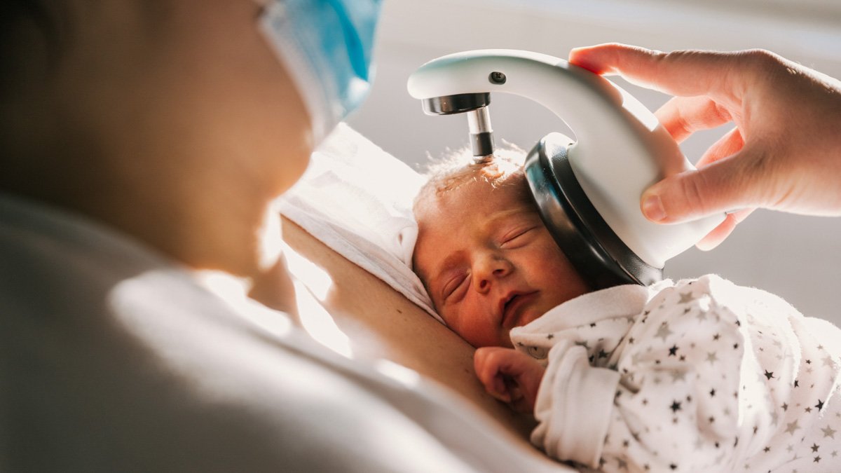 Verktyg för testning av hörsel används på nyfödd bebis 