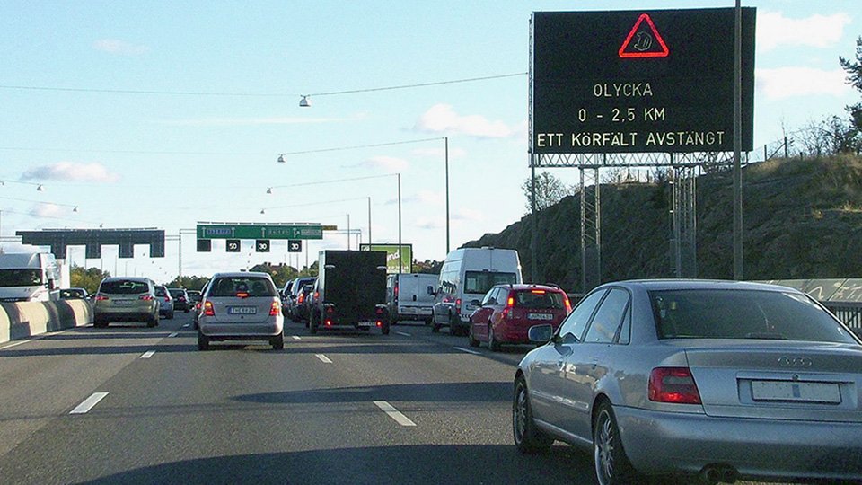 Motorväg med bilar och varningsskylt för att en olycka inträffat.