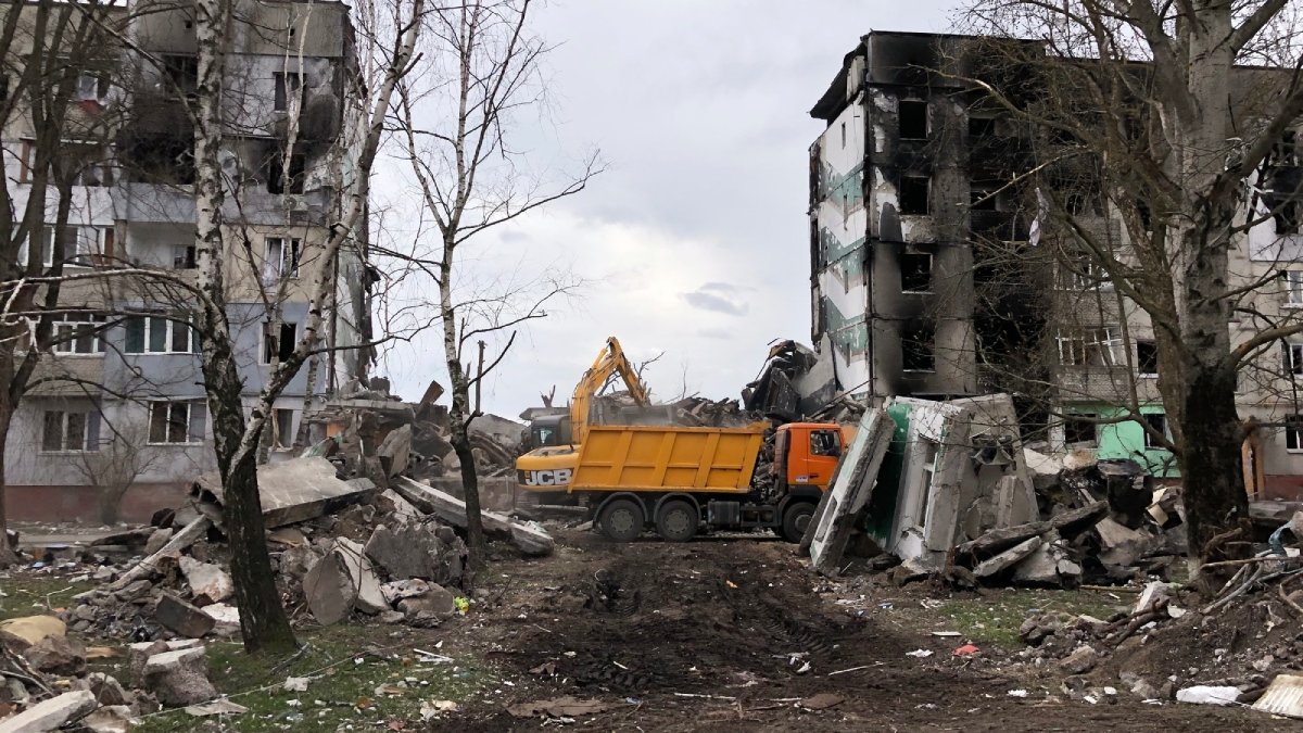 Ett krigsförött kvarter, trasiga byggnader, bitar av betong, en lastbil.