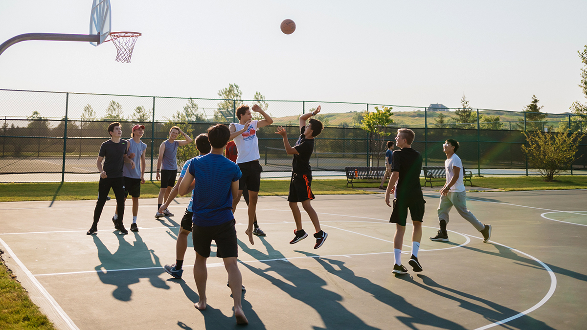 Tonåringar spelar basket.