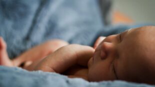 Närbild på nyfödd som ligger och sover.