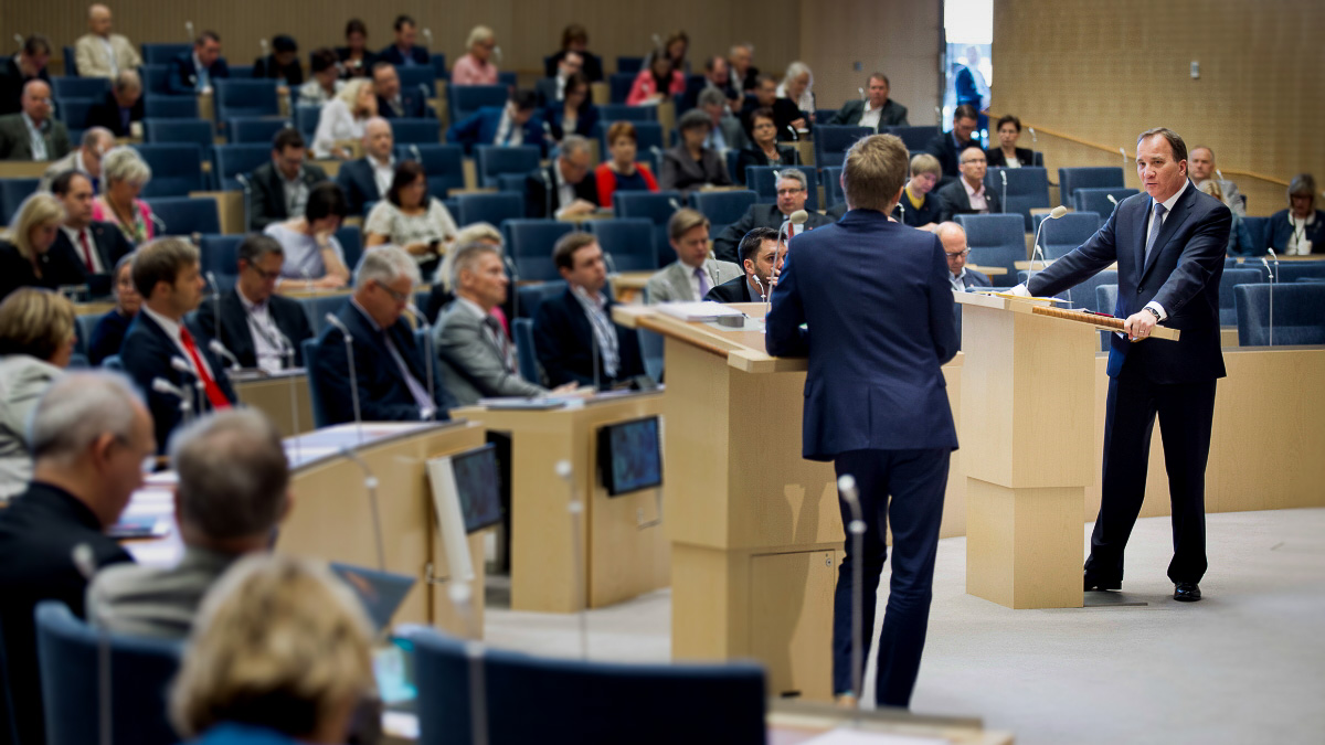 Partiledardebatt, två talare vid talarstolar i riksdagen.