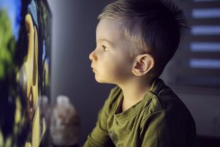 Liten pojke som tittar på en stor skärm.