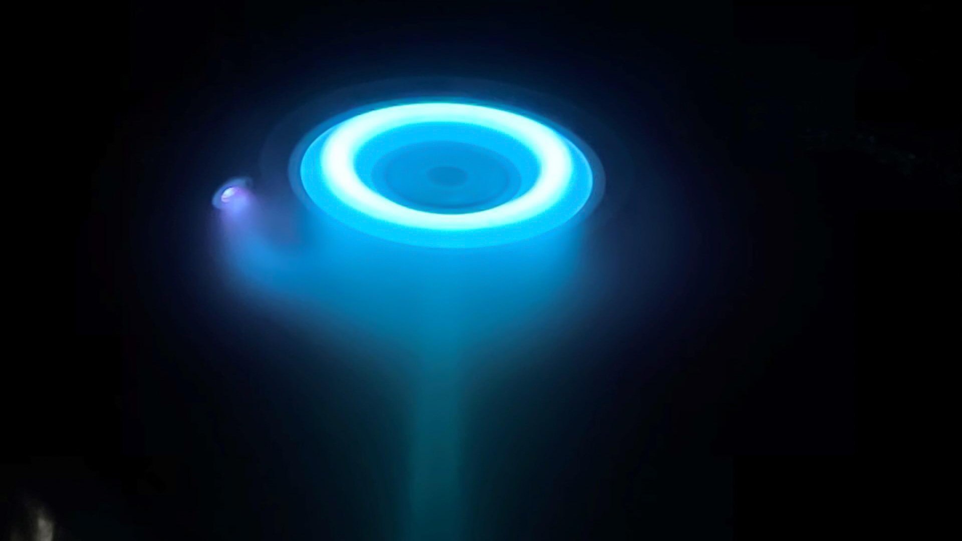 En rund ring av blå eld som skjuter ut ur en raketmotor.