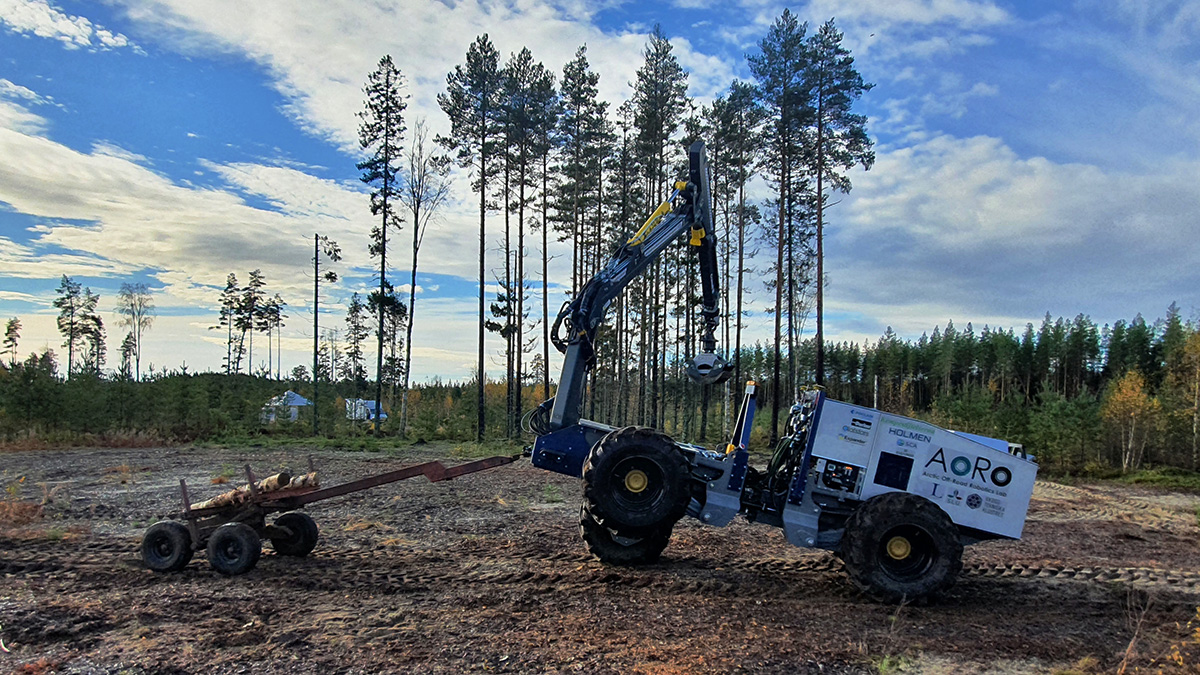 Självkörande skogsmaskin som lastar på timmer.