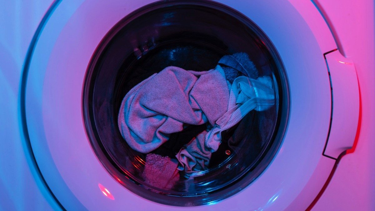 Tvätt inuti tvättmaskin, lila ljus över bilden