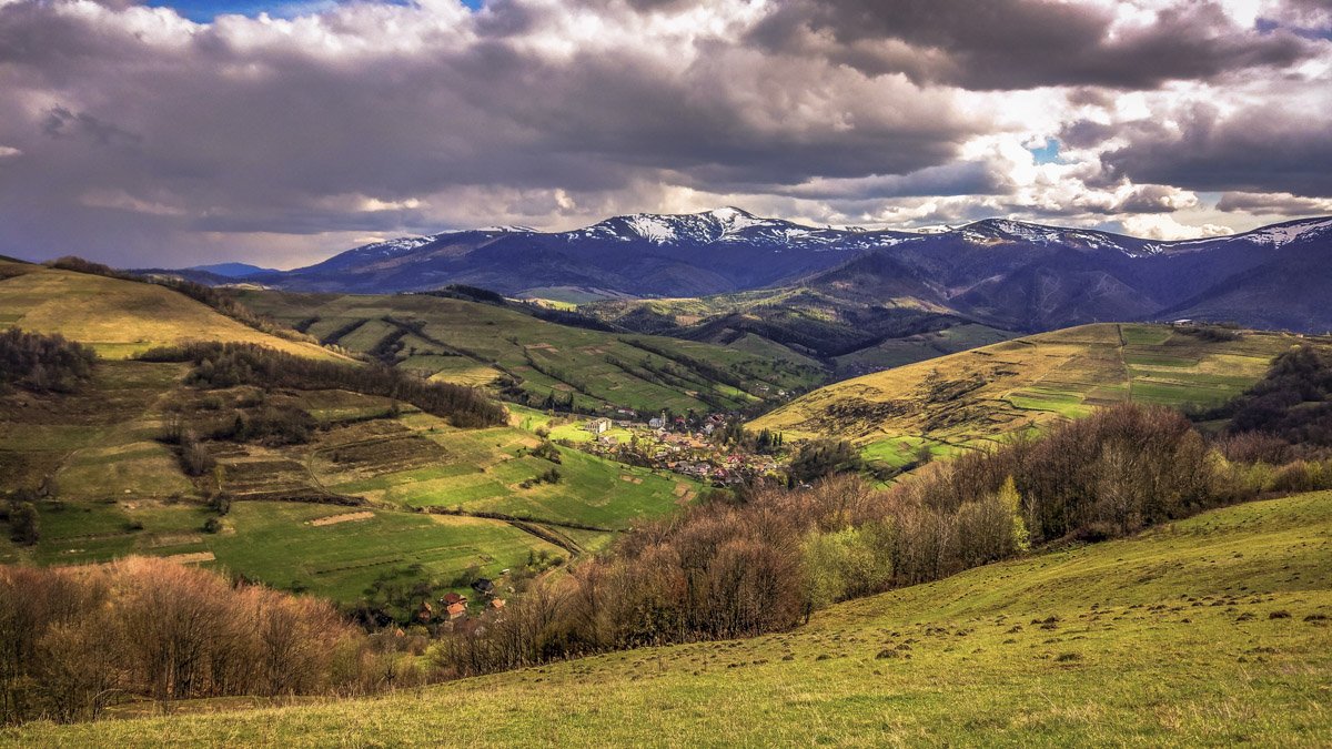 bergslandskap på våren med utsikt över en liten by placerad i en dal