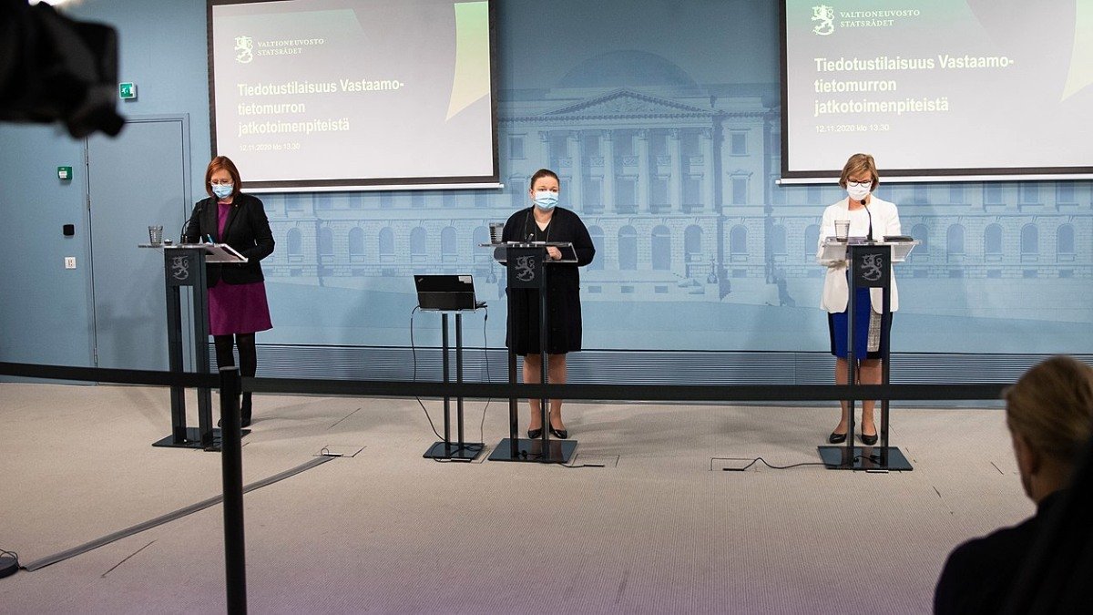 It-skandal, presskonferens med tre personer som står på en scen, alla bär munskydd.