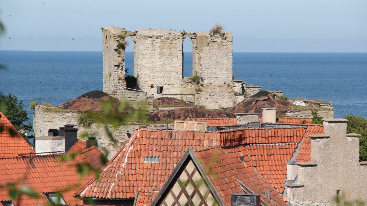 Vy över Visby, tak och ruin. Sommartid.