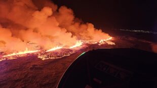 Vulkanutbrott från ovan, nattetid, stora mängder lava och rök.