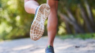 Man ute på joggingtur bland träd