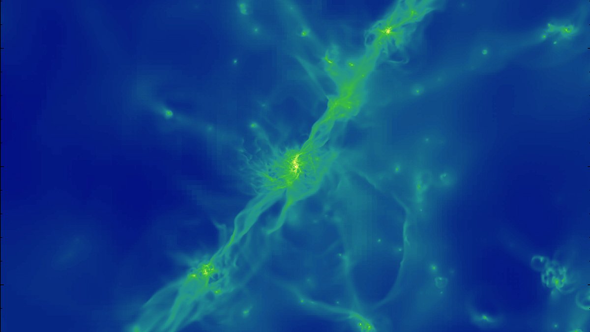 I mitten ses ett lysande gasformation. Små galaxer dyker upp runt omkring.
