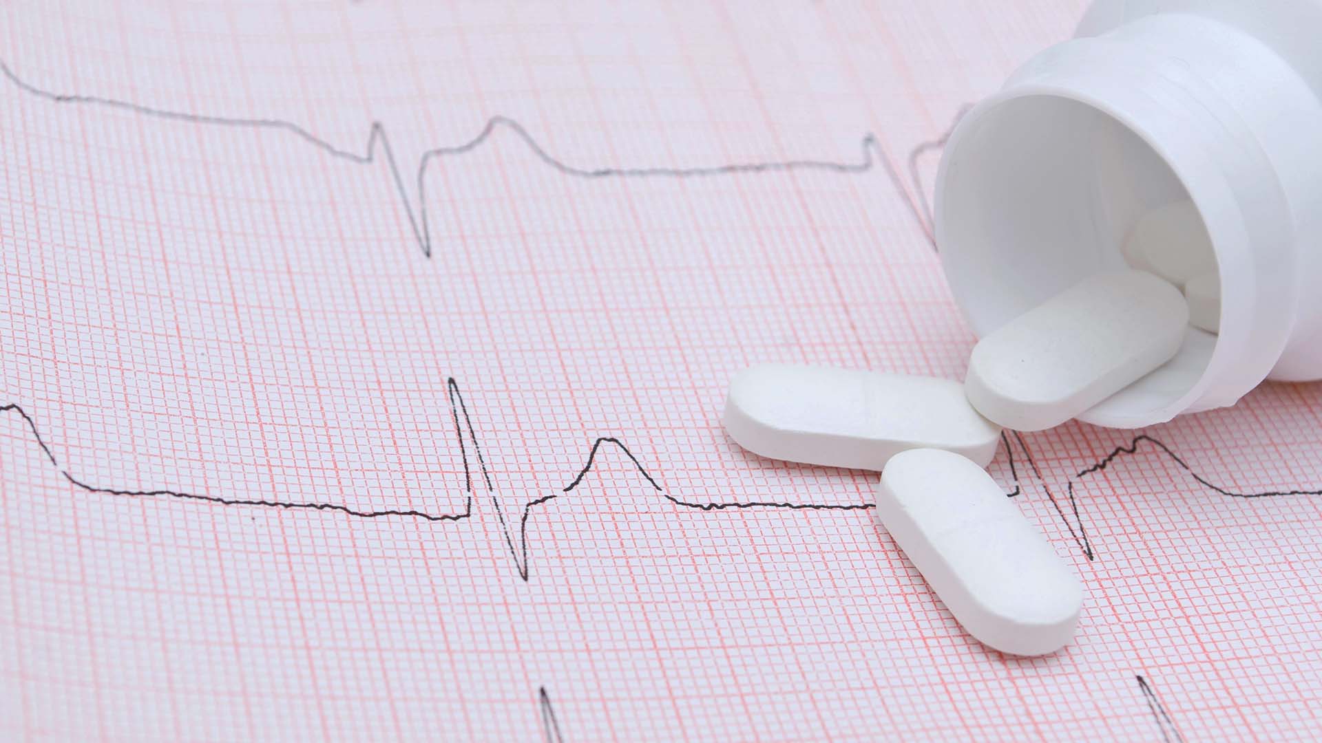 Tablettburk och en EKG-kurva.