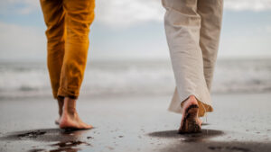 Två människor som gör fotspår i sanden