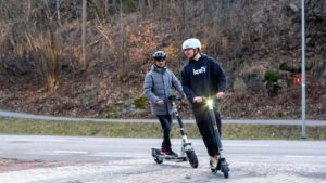 Två personer kör elsparkcykel