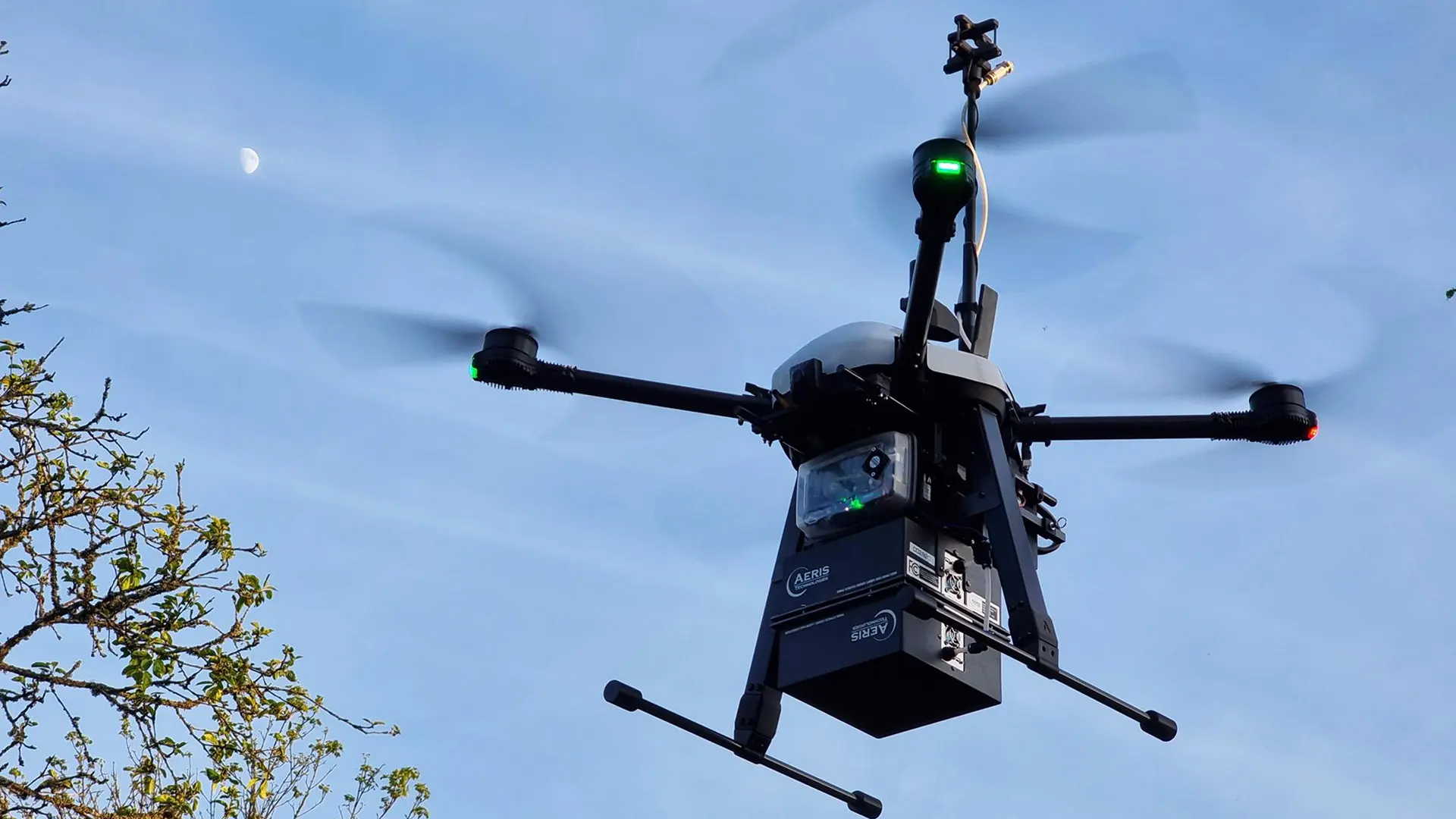 En svart drönare surrar i luften