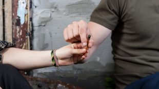 Två unga delar en cigarett med cannabis